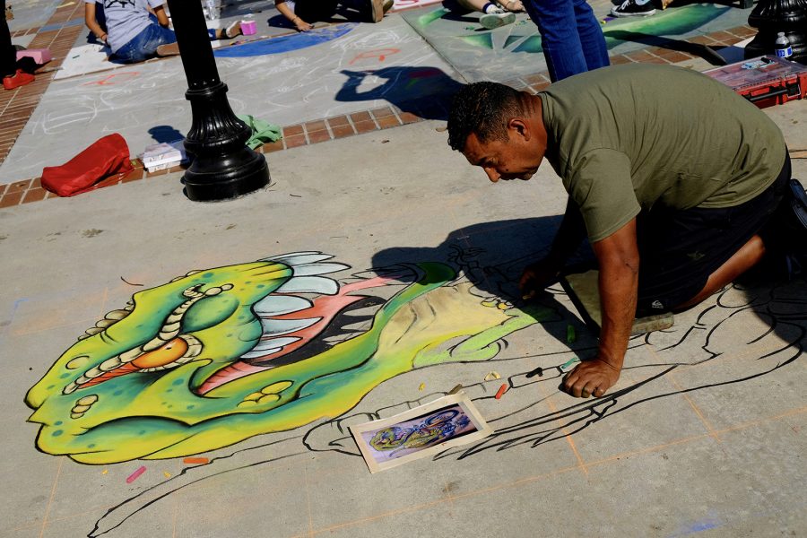An artist draws a T-Rex at the Pomona Chalk Art Festival. Photo by Doug de Wet/SAC Media.