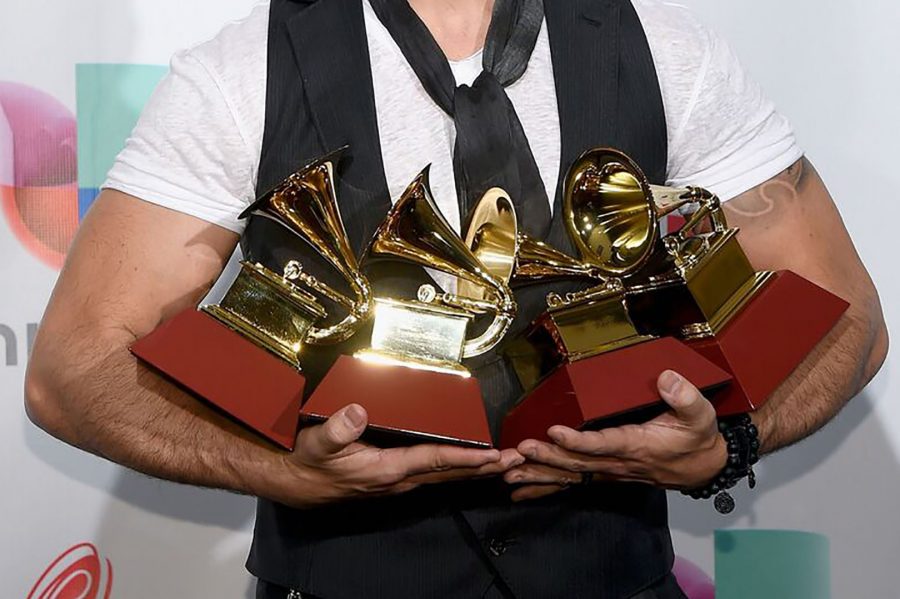 Luis Fonsi holding his 4 Grammy's he won at the 18th Annual Latin Grammy. Photo Credit: Fabian Waintal