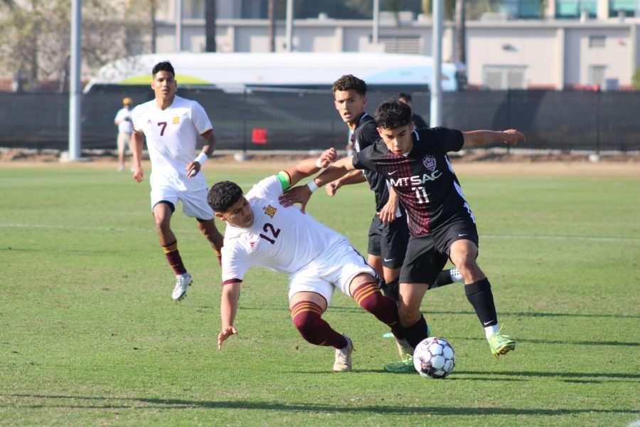 Edward Castro (11) avoids numerous attempts to steal possession and moves the ball upfield.