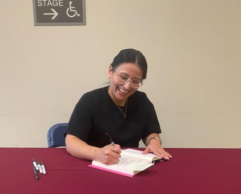 Dr. Alma Zaragoza-Petty signing a book during the event.