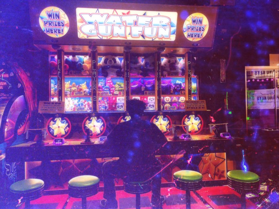 A person plays alone at an arcade machine.