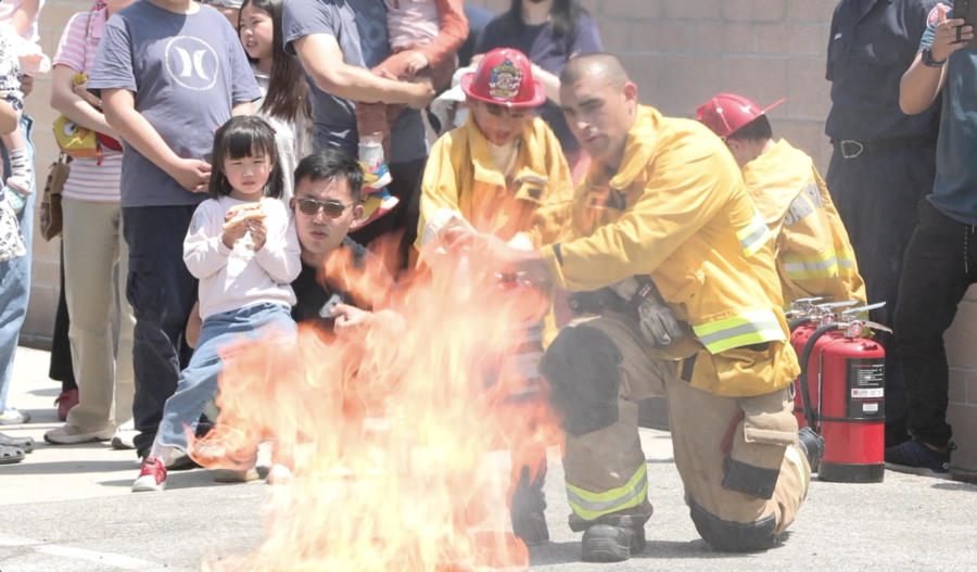 A firefighter teaching children how to use a fire extinguisher.