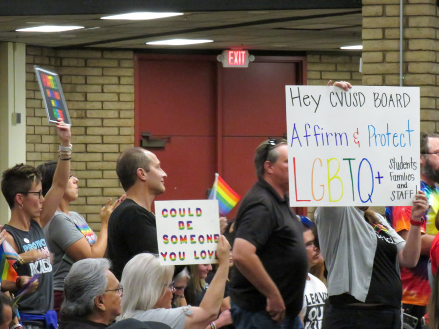 Attendees in opposition of the Chino Valley Unified school board’s policies hold up signs in protest at the June 15 school board meeting at Don Lugo High School in Chino, California.