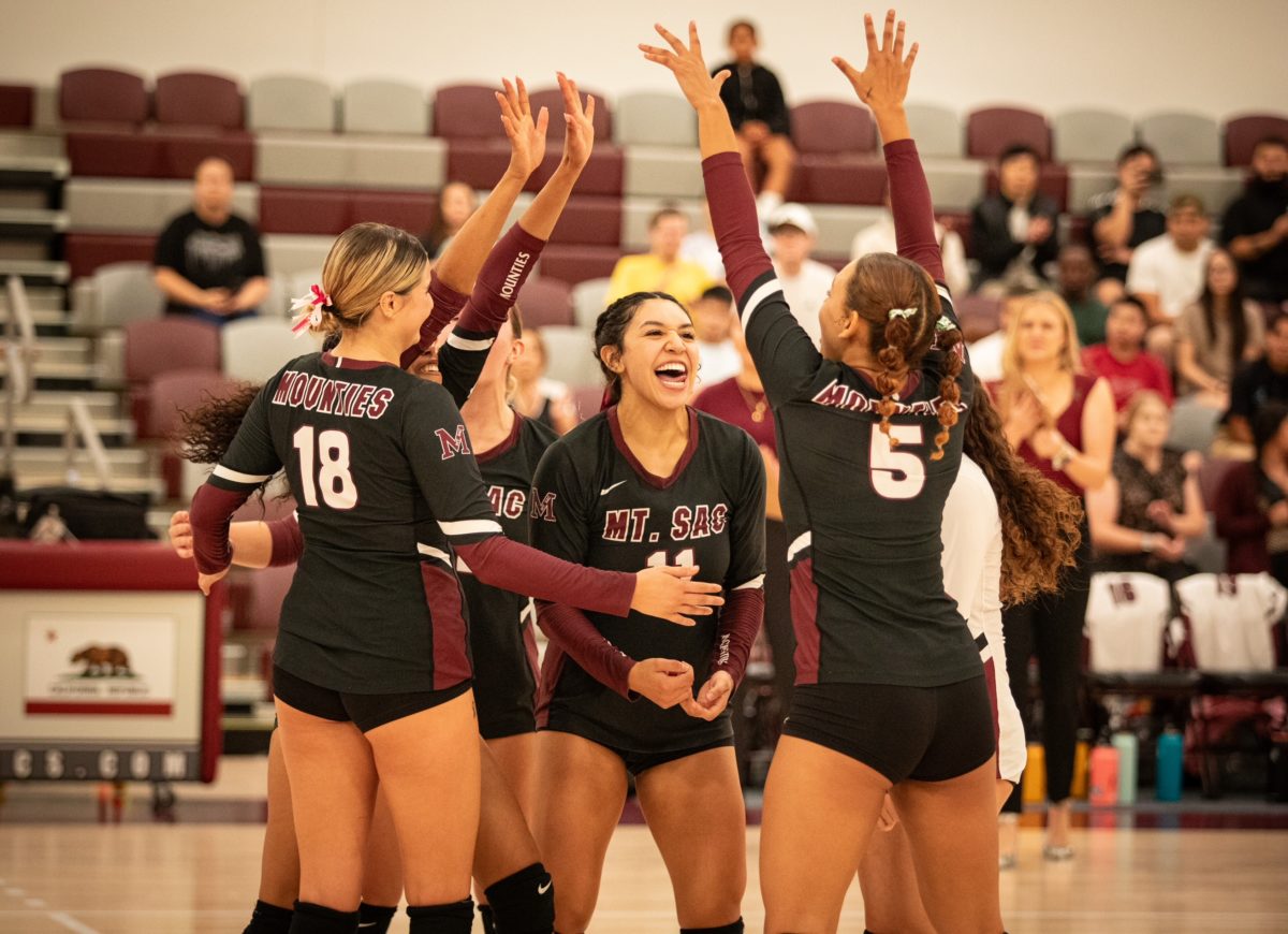 Freshman outside hitter Candace Ceballos (11) celebrating a good play with her teammates.