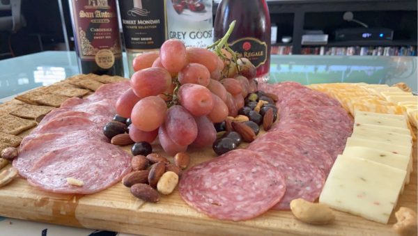 Preparing a charcuterie board with a glass of wine is a great way to unwind and get to know yourself.