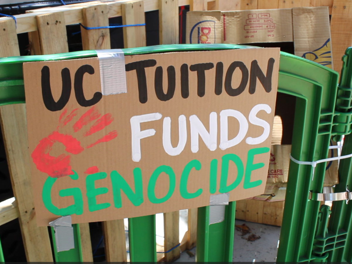 Poster stating UC Tuition funds Genocide on the barrier of the UCI encampment. 