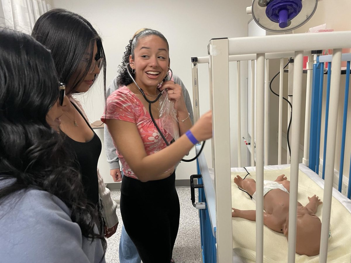 Future students interacting with a medial model of a newborn.