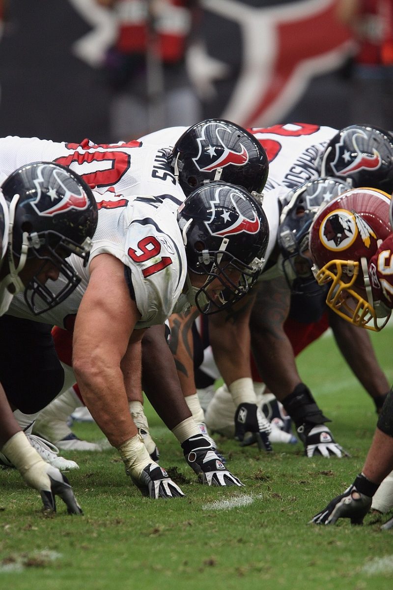 NFL football players getting ready to start another play.