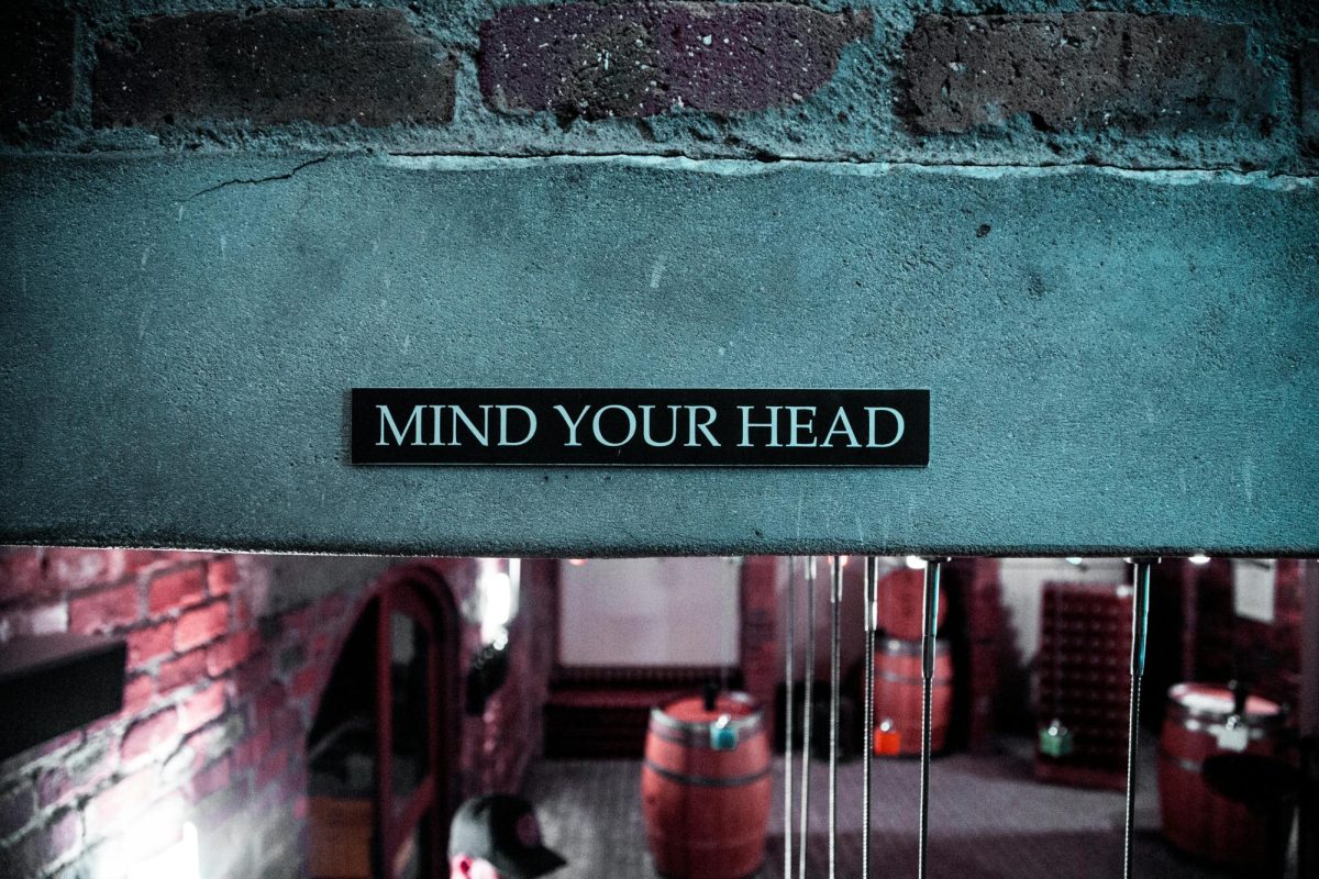 Sign above walkway reading "mind your head."