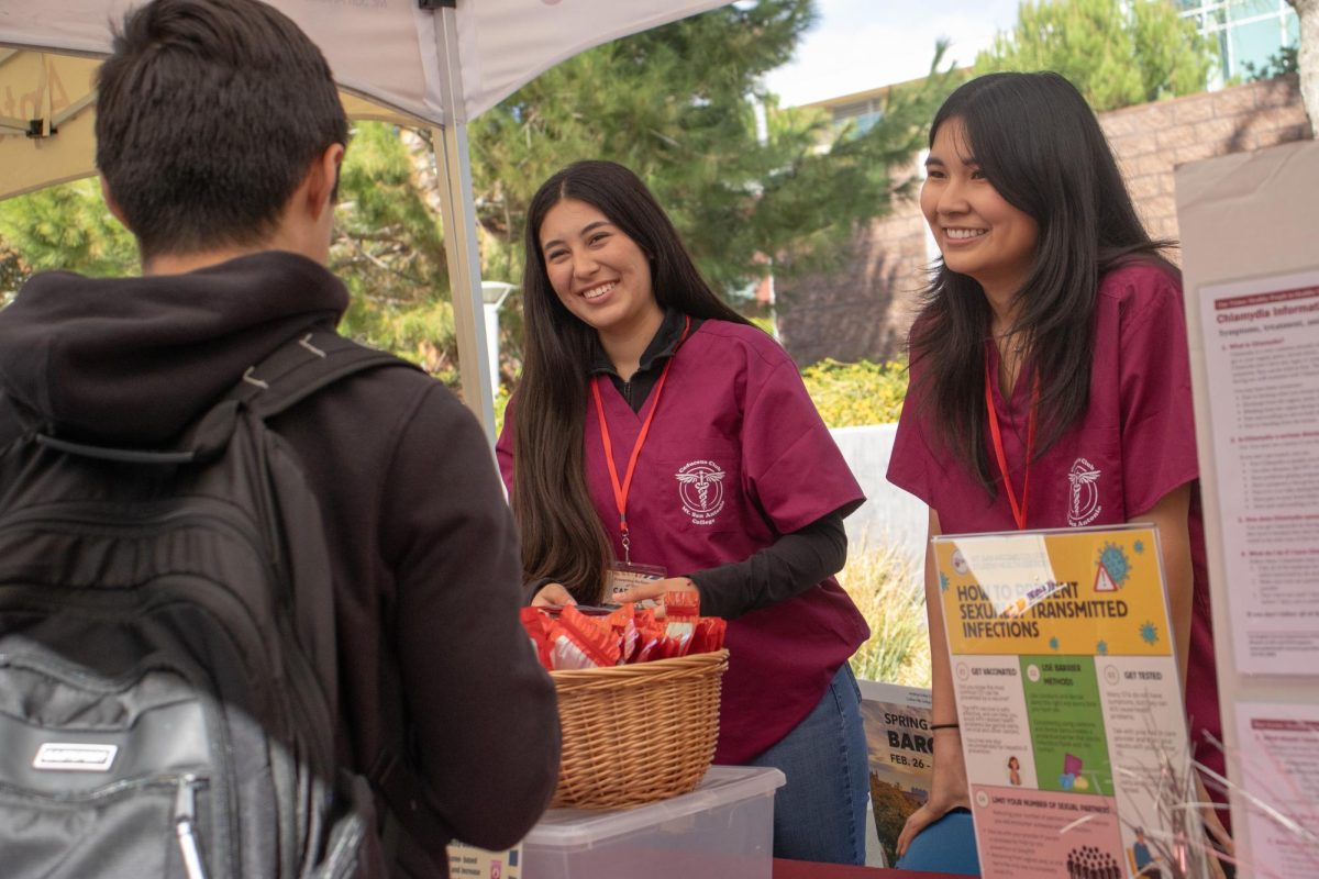 Rebecca De La Torre (19) majoring in animal science and Aletha Flores (19) majoring in nursing passing out free STI kits and informing students how to prevent sexually transmitted infections.