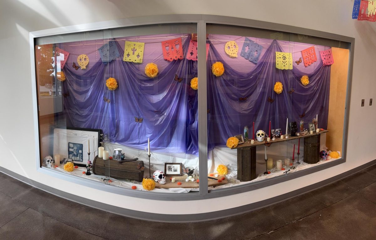 An altar display featuring photographs, candles, papel picado, and decorations inside Building 13 as part of Mt. SAC’s “Recuerdos De Ti” exhibition.