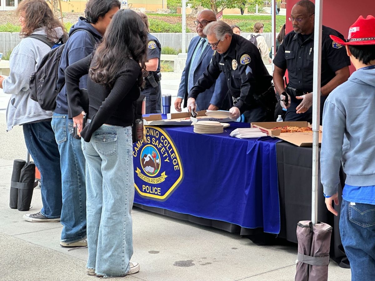 Mt. SAC Campus Police officers serve pizza to students during the Pizza and Patrol event outside the Student Center.