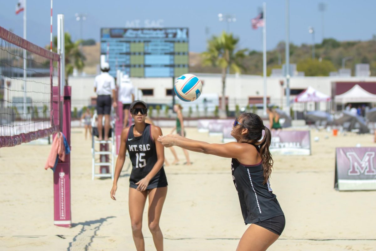 Emma Carson (12) passes the ball over the net during the third game against American River College.
