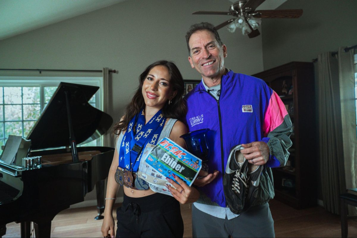 Sophia Ebiner and Matthew Ebiner hold their memorabilia from their past running days.